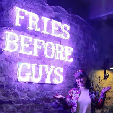 Fries Before Guys purple Custom Neon® sign on a brick wall @brewskirestaurants