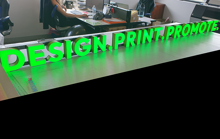 Green front lit sign for Design agency