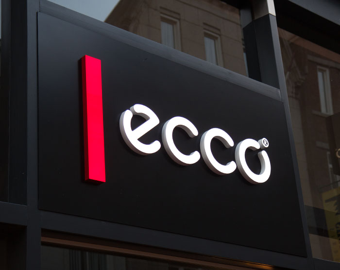 White face lit logo sign on black backing