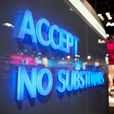 Accept no Substitutes fully lit 3d acrylic letters in light blue LED on dark glossy wall
