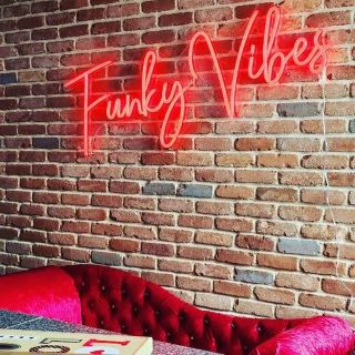 Custom Neon® red Funky Vibes sign on brick wall @absternash