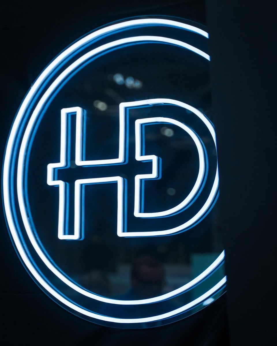 White Custom Neon® logo on a black backdrop @hdhouseofdental