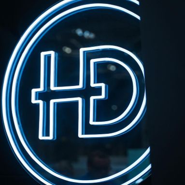 White Custom Neon® circle HD sign on a black background