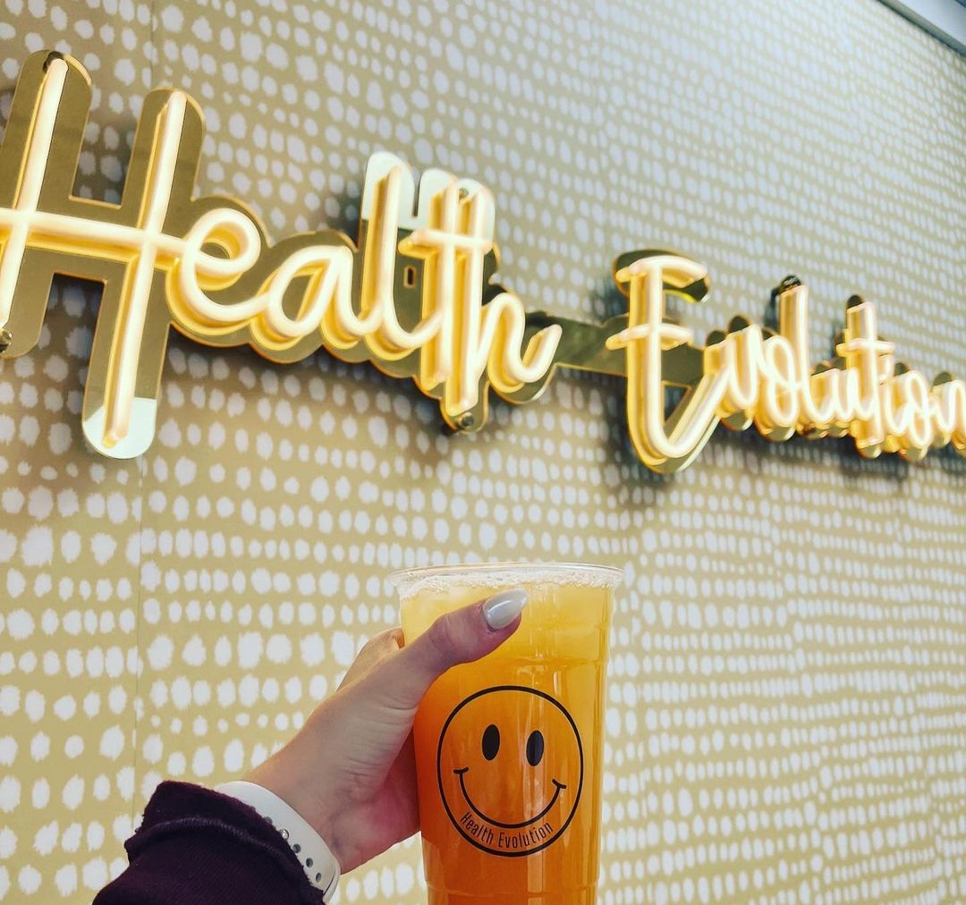 @health.evolution.mn warm white Custom Neon® retail sign on gold mirrored acrylic backboard