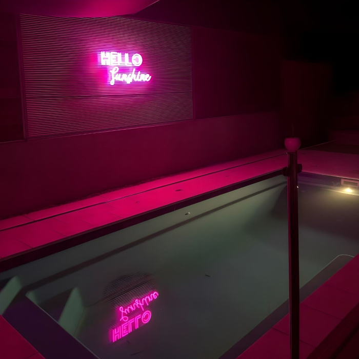 Custom Neon® pink waterproof sign above swimming pool @melissawickham