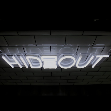 White Custom Neon® logo sign made for @hideout.barbers
