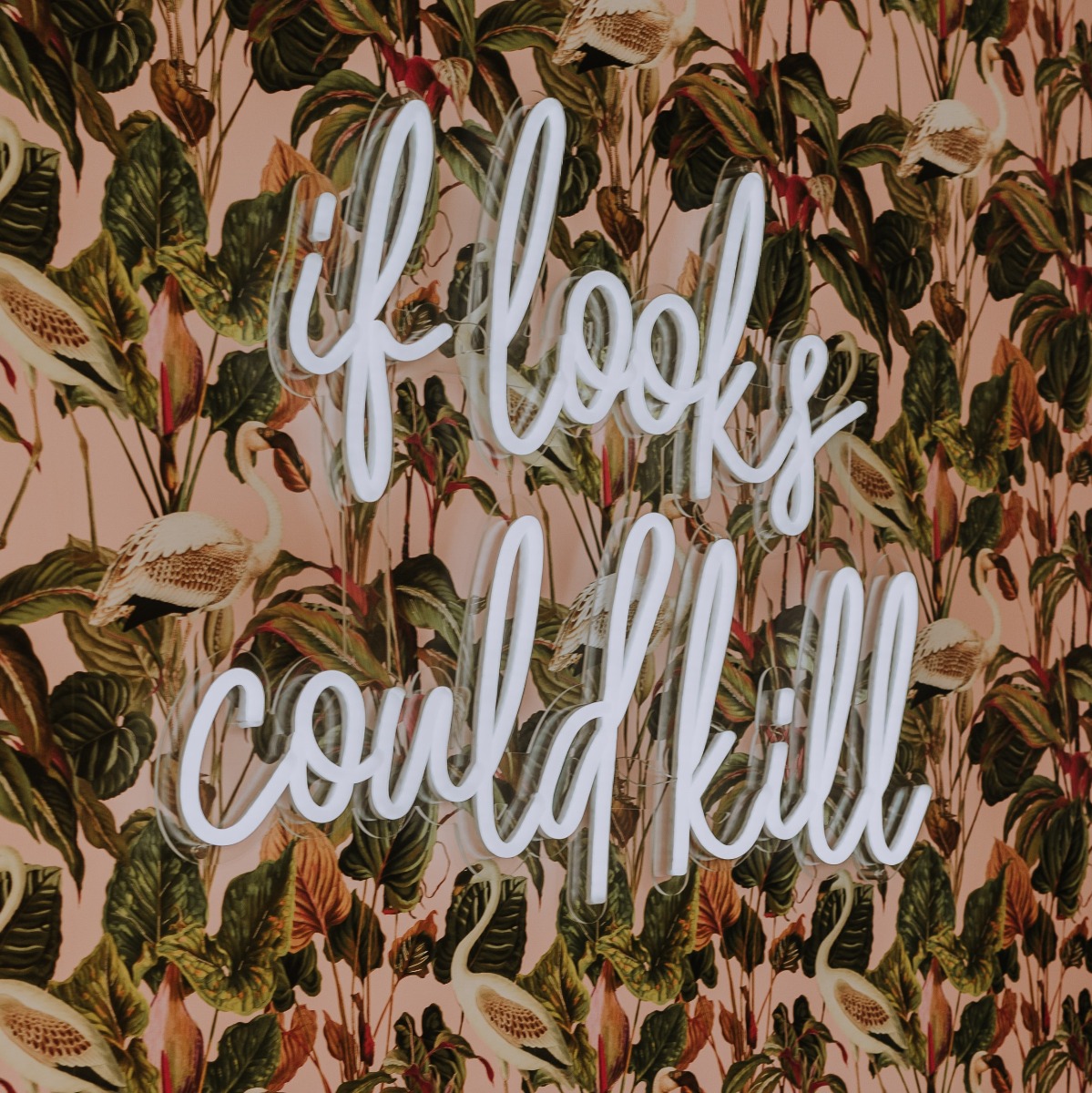 White Custom Neon® sign in a script font on a wallpapered wall in a hair salon @dollsandsailors