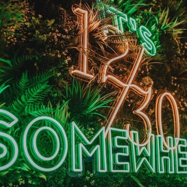Custom Neon® large tagline sign reading It's 12 30 Somewhere @thetwelvethirtyclub