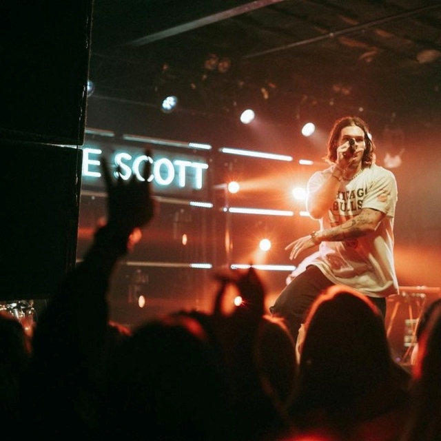 Custom Neon® white personalized stage sign behind the artist during a concert @jakescottmusic