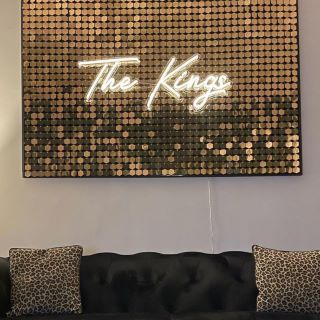 Warm white Custom Neon® family name sign on shimmer wall