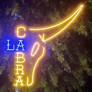 Custom Neon® yellow & blue @lacabramexican logo on clear backboard