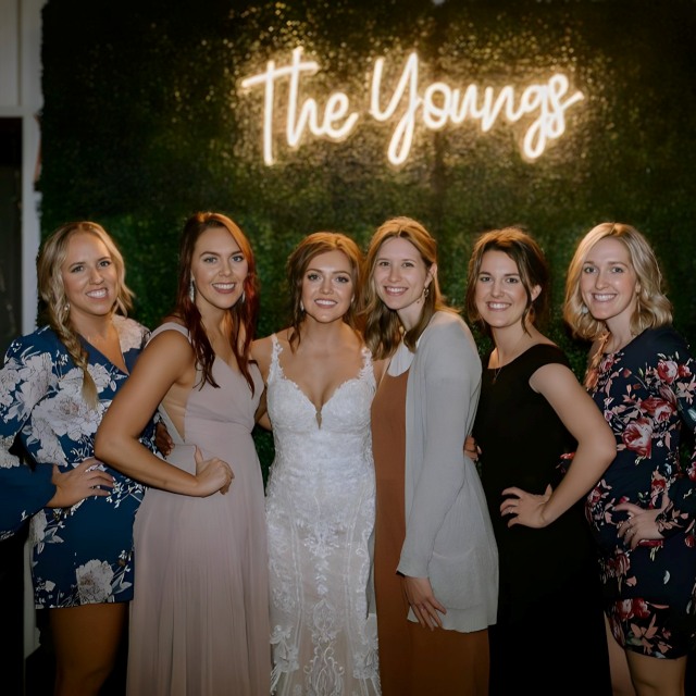 Custom Neon® last name wedding sign mounted on a green wall as a photo backdrop @abbymettling