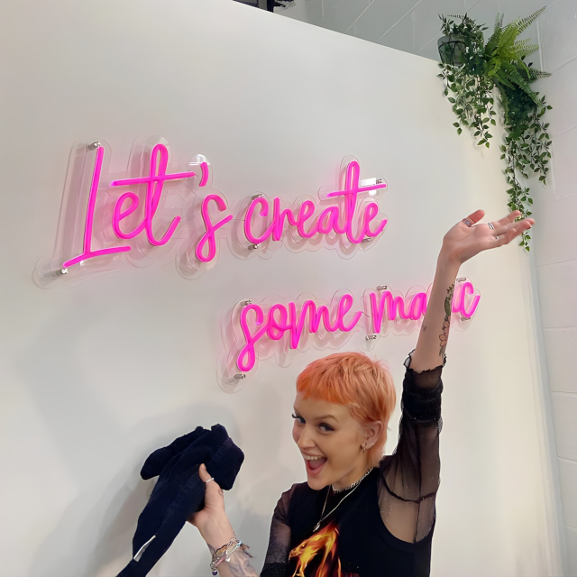 Let's Create Some Magic pink Custom Neon® sign on white wall in @dkc_hairlounge