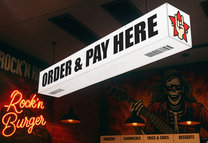 Fully illuminated light box sign suspended from a ceiling