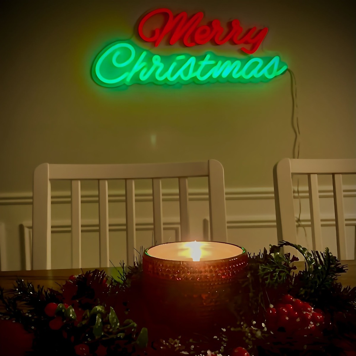 Custom Neon® red and green Merry Christmas sign above a dining room table decorated with candles and holly