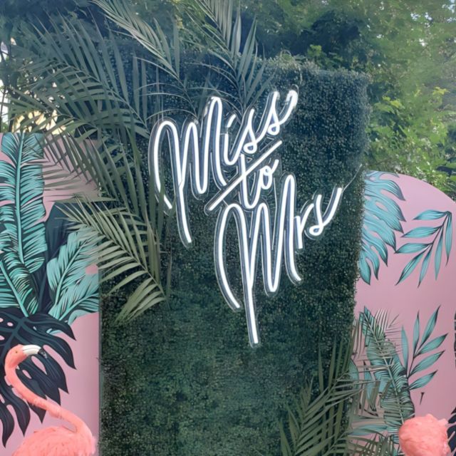 Miss to Mrs Custom Neon® bridal shower sign on a green photo backdrop  @decorandfiesta