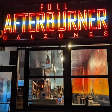 Custom Neon® outdoor pizza restaurant signage above the door