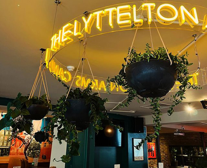 Custom Neon® circular hospitality business name sign handing from the ceiling