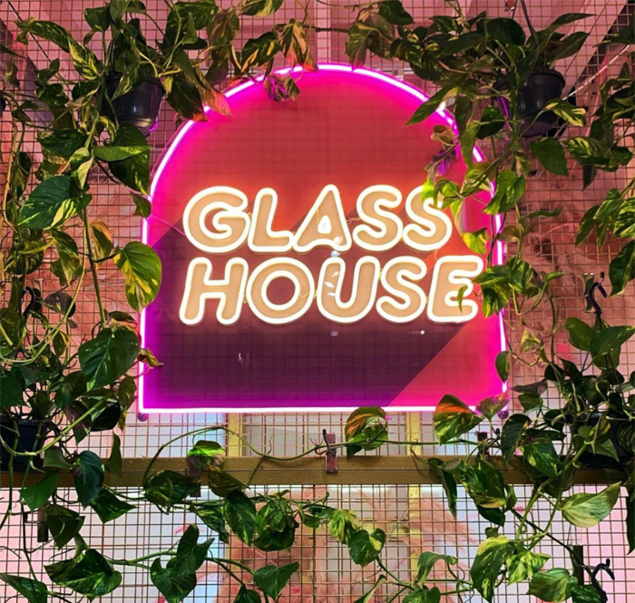 Custom Neon® pink & warm white UV print LED neon logo hanging in a plant store