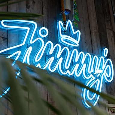 Custom Neon® blue business name sign on wood paneled wall