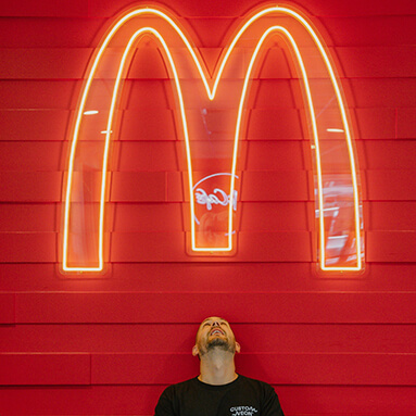 Custom Neon® yellow LED neon McDonalds arches sign on a red wall in a McDonalds fast food store