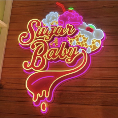 Custom Neon® large logo sign for @sugarbabyhyperdome in multiple colours with a UV print backing mounted on a wood pannelled wall