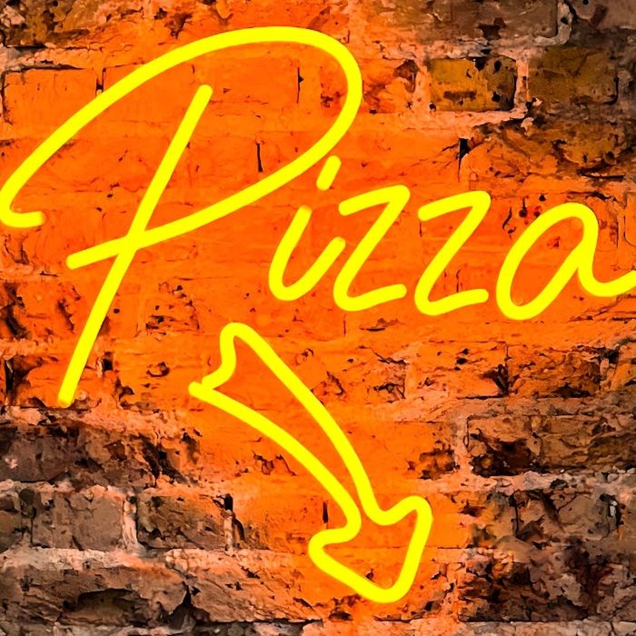 Directional Pizza sign with an arrow in orange LED neon on a brick wall @bridge_baker
