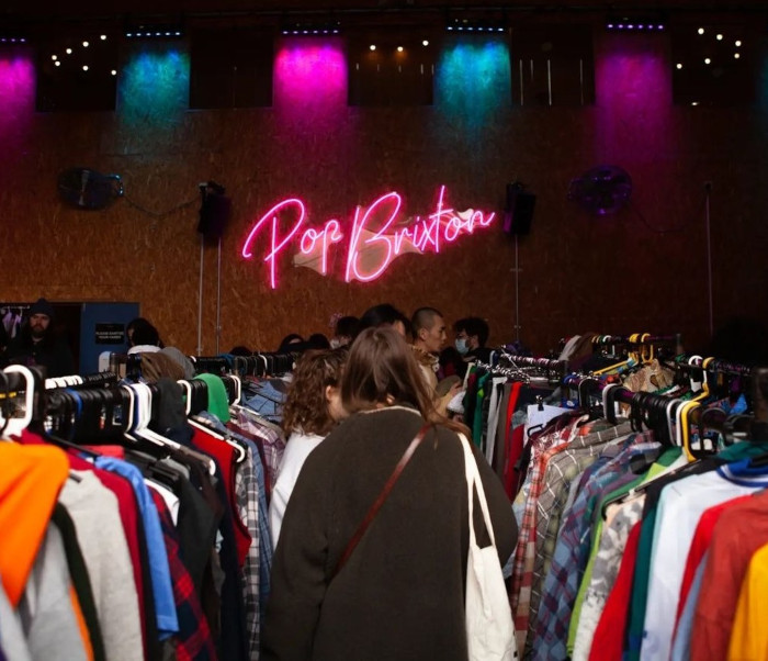 Custom Neon&reg; @popbrixton signage in the background of a pop up retail event
