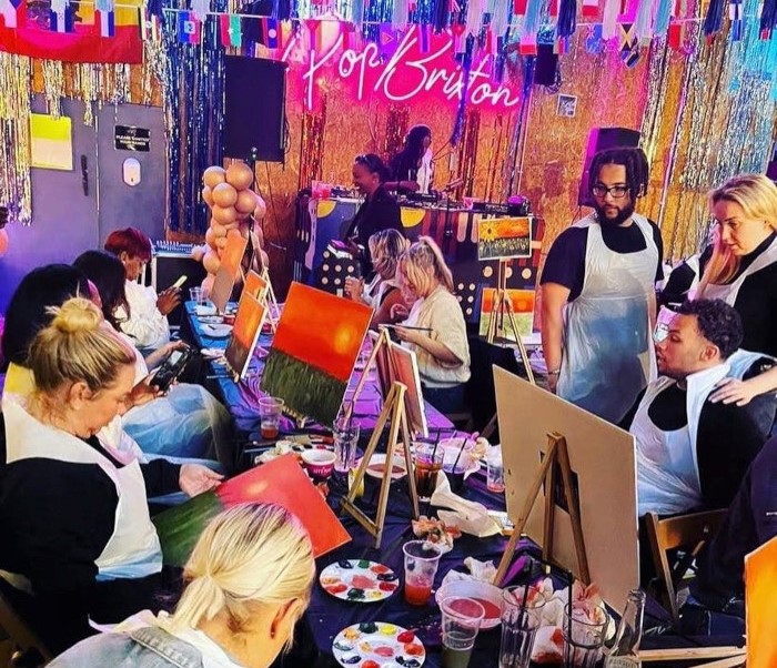 Custom Neon&reg; @popbrixton sign in the background of an art event @wruspaintparty