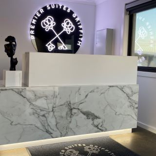 Custom Neon® white sign on black backing @premiersuitegriffith