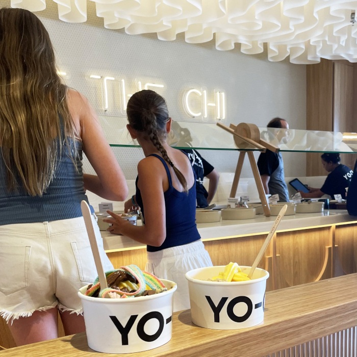 Share the Chi warm white Custom Neon&reg; sign with Yo-Chi yoghurt cups in the foreground at the @iloveyochi store