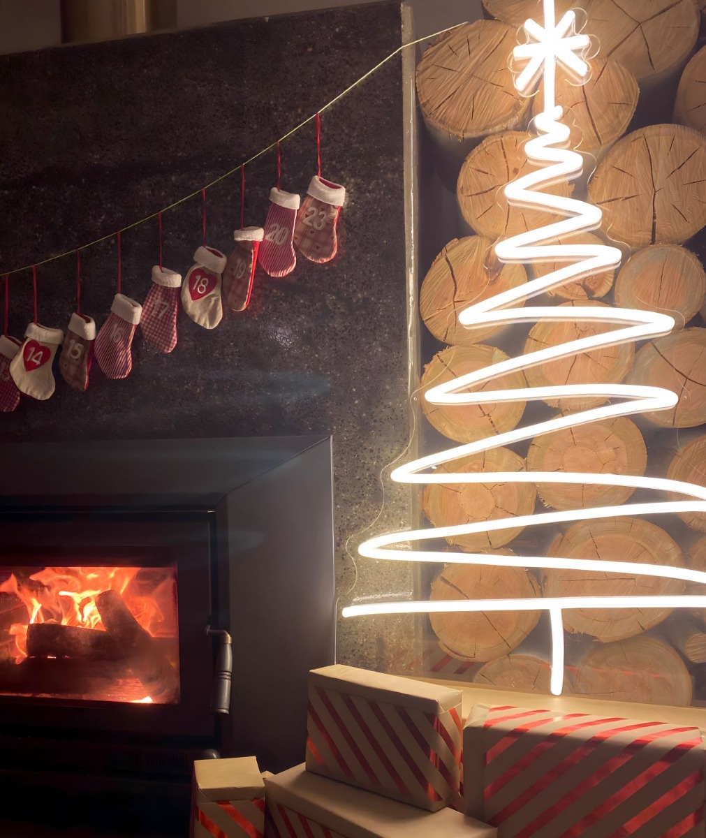 Custom Neon® warm white LED Xmas tree next to the fireplace with presents underneath