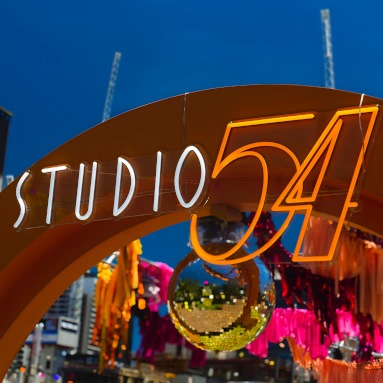 Weatherproof Custom Neon® Studio 54 sign on an arch at the entrance to an open air corporate event organized by @ultimo_catering