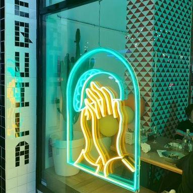 Custom Neon® LED neon art of prayer hands holding taco shells in the window at @elsantogeelong