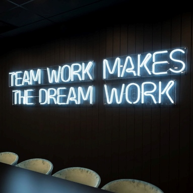 Teamwork makes the dream work large Custom Neon® sign on a dark wall in an office boardroom @iconinteriors.net.au