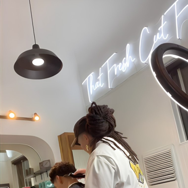 That Fresh Cut Feeling white Custom Neon® sign above the barber chair @dinosbarbershopsd
