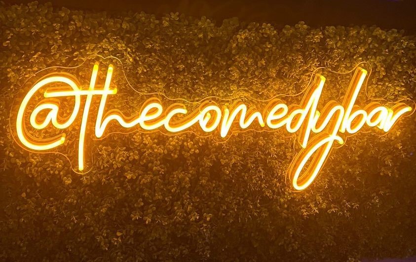 Orange Custom Neon® social media handle sign @thecomedybar