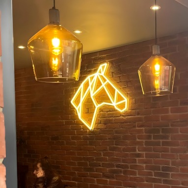 Custom Neon® yellow horse head logo on brickwall @thedarkhorse