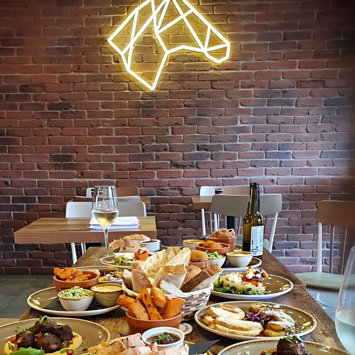 Yellow Custom Neon® horse head logo on brickwall @thedarkhorseyork