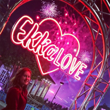 Custom Neon® red LED neon outdoor festival sign hung from a metal arch