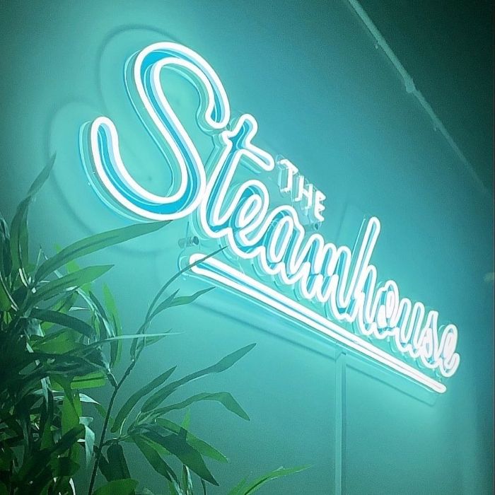 The Steamhouse mint green Custom Neon® bakery name sign on the wall @thesteamhousebakery