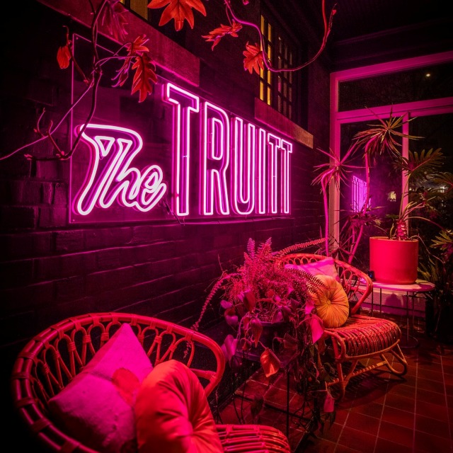 The Truitt Custom Neon® sign in the outdoor lounge area of @thetruitt