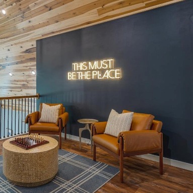 This Must be the Place warm white Custom Neon® sign in an Airbnb loft decorated by @somerled.designs