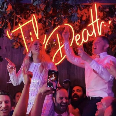 Large red Til Death sign by Custom Neon® behind the newlyweds at a wedding venue @thewarehousegeelong