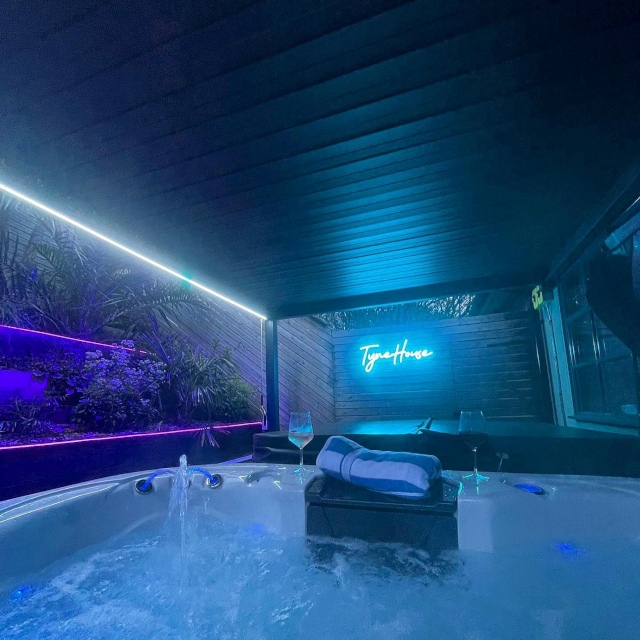 Blue Custom Neon® waterproof TyneHouse sign above the spa