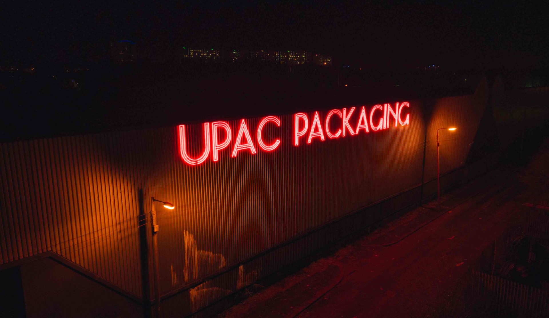 Large red Custom Neon® outdoor building sign @theupacgroup