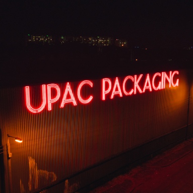 Large red Custom Neon® outdoor building sign @theupacgroup