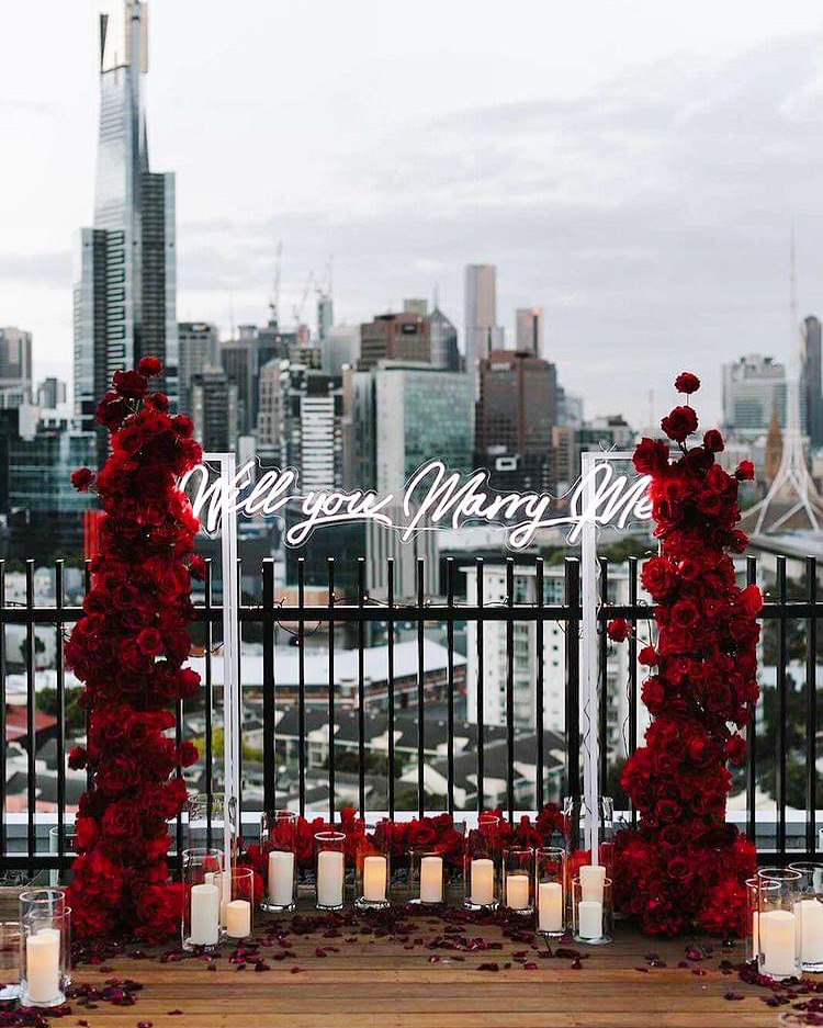 Will You Marry Me white Custom Neon® sign with the London skyline in the background  @_theproposers