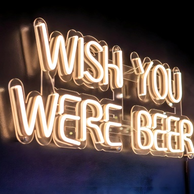 Wish You Were Beer warm white Custom Neon® sign on a dark wall @blackshirtbrew