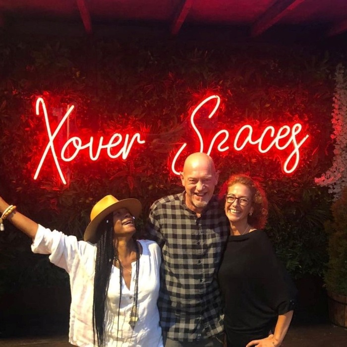 Red Custom Neon® venue name selfie sign on a greenwall @xoverspaces